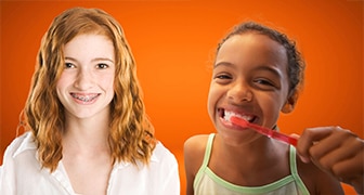ragazze sullo sfondo arancione, una delle quali si lava i denti ragazze sullo sfondo arancione, una delle quali si lava i denti